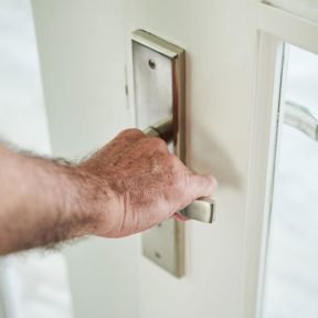 hombre-anonimo-recortado-sosteniendo-manija-puerta-abrir